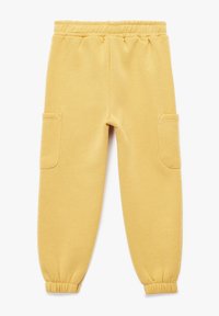 Pantalones de chándal amarillos con cintura elástica, puños elásticos y dos bolsillos laterales. Tela suave con una textura lisa.