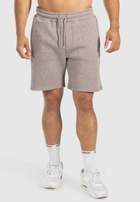Pantalones cortos de mezcla de algodón en color gris con cintura elástica y cordón, que presentan bolsillos laterales y un ajuste relajado, combinados con zapatillas blancas.