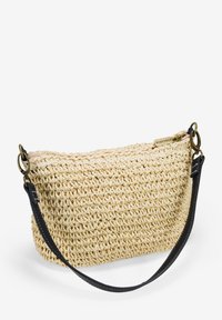 Borsa in paglia intrecciata di colore beige naturale con tracolla in pelle nera. Dotata di chiusura con zip e design minimalista con superficie texturizzata.