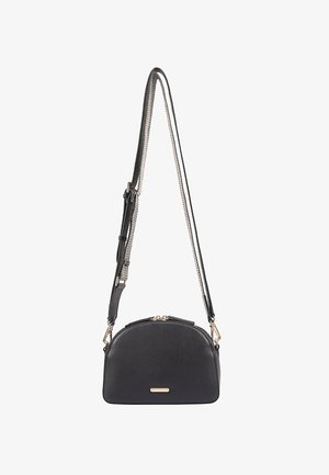 Black leather crossbody bag with a curved shape, contrasting chain and strap, gold hardware accents, and a zip closure.