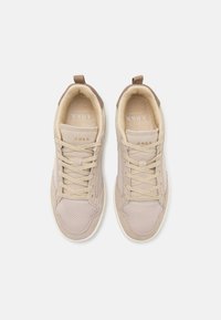 Beige sportsko med teksturert mesh-overdel, glatte semskede detaljer og beige snørebånd. Gummisåle med merkevare på tungen.