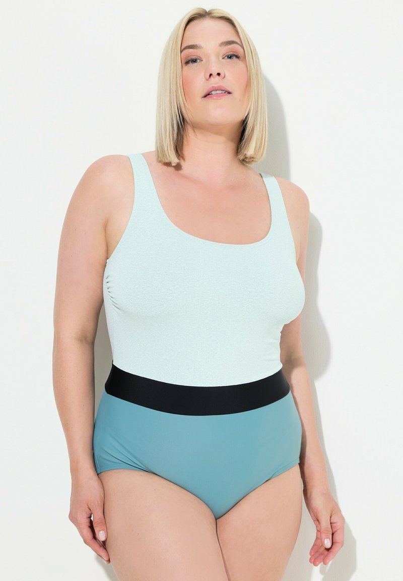 Maillot de bain une pièce bleu clair avec un décolleté en forme de cœur, un tissu texturé et une ceinture noire, présentant un design à jambe haute.