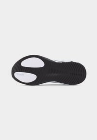 Semelle de chaussure de sport en noir et blanc avec une bande de roulement texturée et deux sections de grip blanches, affichant le logo de la marque Continental sur une des zones de grip.