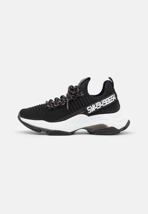 Czarne sportowe buty z wytrzymałą siateczką, wzorzystymi sznurówkami i kontrastującą białą podeszwą środkową. Charakteryzują się odważnym białym napisem po boku.