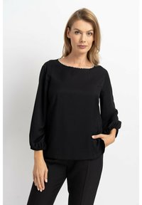 Schwarze Bluse mit rundem Halsausschnitt, verziert mit kleinen Perlen. Hat lange, puffige Ärmel mit elastischen Bündchen und einer glatten Stoffoberfläche.