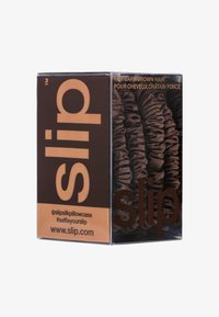 Dunkelbraunseide-Kissenbezug in einer rechteckigen Verpackung. Auf der Vorderseite ist der Markenname "slip" deutlich sichtbar, zusammen mit Anwendungshinweisen.