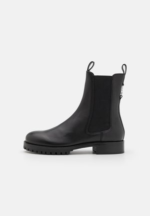 Black leather ankle boot with elastic side panels, a rounded toe, textured rubber outsole, and pull tabs on the back for easy wear.