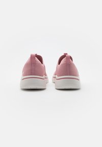 Zapatillas deportivas rosas con parte superior texturizada, ajuste elástico, suela blanca y acentos rosas contrastantes. Compensaciones en el talón para facilitar el uso.