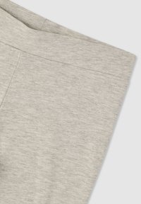 Jasnoszary odzież wykonana z miękkiego, teksturowanego materiału. Posiada prosty, czysty krój bez dodatkowych wzorów czy detalów metalowych.