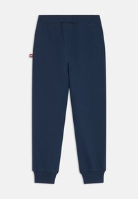 Marineblaue Baumwoll-Jogginghosen mit geripptem Bund und Bündchen, ausgestattet mit einem kleinen Logo-Tag auf der linken Seite. Glatte Textur, taillierte Passform.