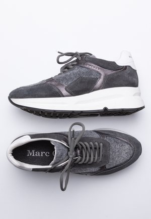 Paire de baskets en daim gris foncé et noir avec semelles blanches, vues de dessus et de côté, avec lacets et cols rembourrés.