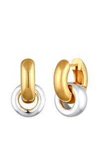 Des boucles d'oreilles en or et en argent prennent la forme de cerceaux avec un design poli et arrondi, présentant une texture lisse et des éléments circulaires entrelacés.