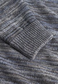 Grau gestrickter Pulloverstoff mit unterschiedlichen blauen und grauen Streifen. Der Bund hat eine gerippte Struktur mit engem Gewebe für eine sichere Passform.