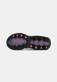 Black and purple sneaker sole with a textured grip pattern and pink circular accents on a white background.