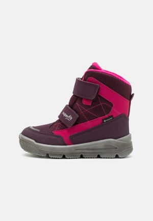 Bottes waterproof violettes et roses avec une surface texturée, dotées de bandoulières Velcro, d'un col rembourré et de semelles en caoutchouc pour l'adhérence.