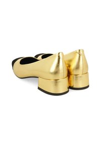 Zapatos de ballet metálicos dorados con una puntera negra y tacones cuadrados. Textura suave con un acabado brillante y diseño redondeado.