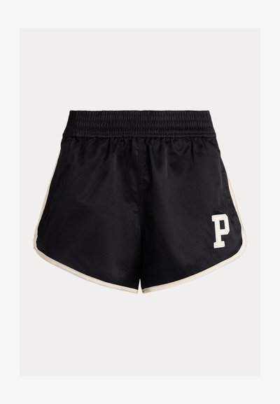 Čierne atletické šortky s elastickým pásom, krémovými bočnými pruhmi a bielym logom "P" v dolnom ľavom rohu. Hladká tkanina, voľný strih.