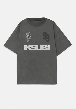 Grå oversized t-skjorte med rund hals. Har hvit "KSUBI" tekst, nummer "99," og et grafisk design. Laget av mykt stoff.