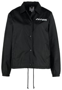 Czarna nylonowa kurtka treningowa z kołnierzykiem, zatrzaskami, elastycznymi mankietami i ściągaczem u dołu. Zawiera logo Vans w białym kolorze.
