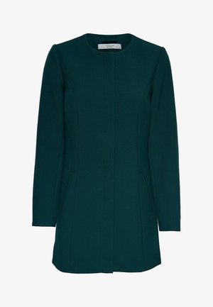 Abrigo verde oscuro a medida con escote redondo, mangas largas y dos bolsillos delanteros. La tela tiene una textura suave y estructurada.