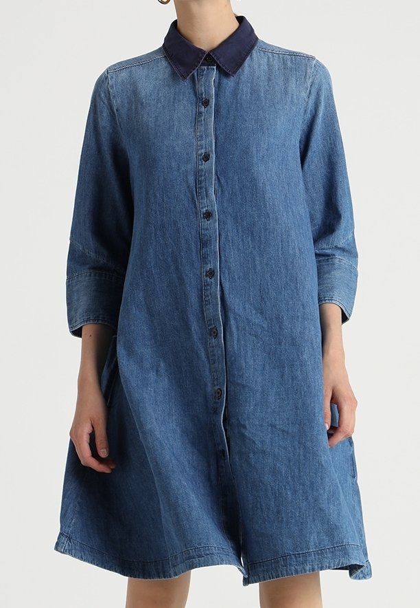Jeansskjolklänning med mörk krage, knappstängning fram och trekvartsärmar, med en lös passform och mjukt, texturerat tyg.