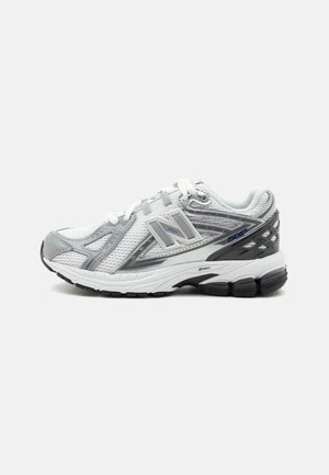 Bielo-šedá bežecká obuv New Balance 1906R s vrchným dielom z sieťoviny, podloženou podrážkou a šnurovaním, zobrazená v bočnom profile na bielom pozadí.