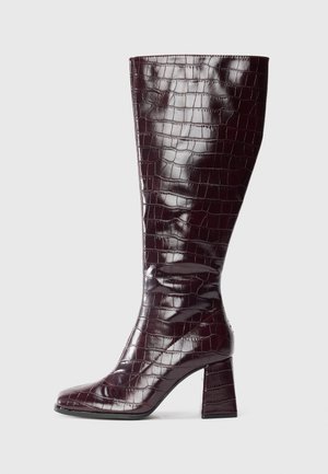 Dark burgundy knee-high boot with crocodile texture and block heel on a white background, shown from the side.