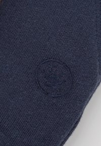Dunkelblaues Strickgewebe mit glatter Textur, mit einem runden, gestickten Logo in der unteren rechten Ecke.