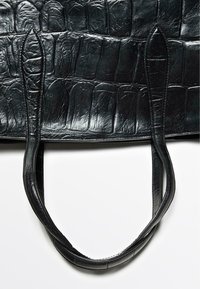 Borsa tote in pelle nera con una texture a motivo coccodrillo. Presenta due manici allungati e una finitura liscia.