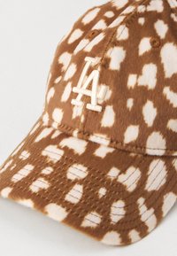 Căciulă de baseball cu model crem și maro, confecționată dintr-un material moale, având un logo brodat LA pe partea din față și detalii cusute pe vizieră.