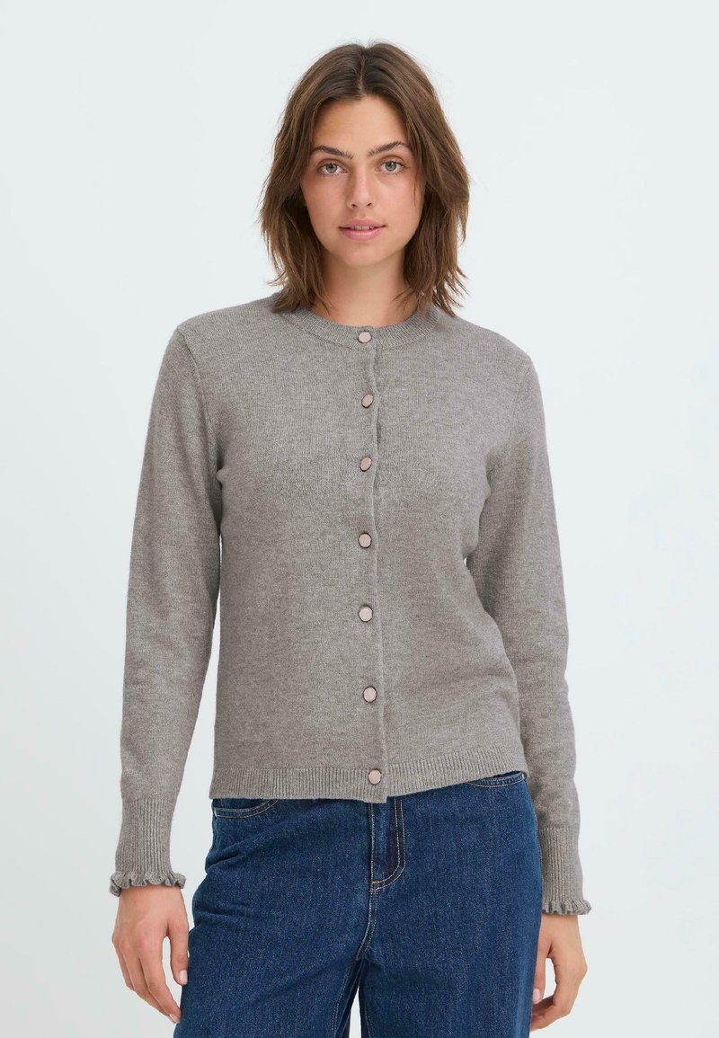 Cardigan en tricot gris avec un col rond, des boutons sur le devant et des poignets volantés. Le tissu a une texture douce et un design ajusté.