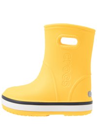 Botte étanche jaune avec une finition texturée, un haut arrondi, une poignée latérale, une bande de semelle blanche et un accent bleu marine en bas.