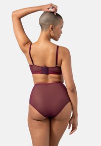 Burgundy underkläder set med en genomskinlig bh som har justerbara axelband och en hakförslutning, i kombination med högmidjade, semitransparenta hipsters.