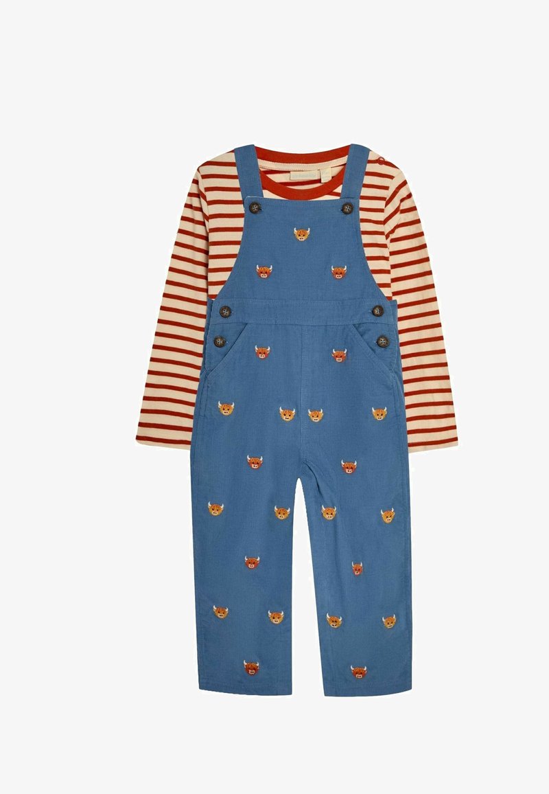 Kék kordbársony overall állatarcokkal hímzett, piros-fehér csíkos hosszú ujjú pólóval párosítva. Állítható pántokkal és gombokkal rendelkezik.