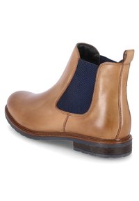 Bottines en cuir marron avec des panneaux élastiques latéraux navy, bout rond et un petit talon empilé. Accents texturés près de la cheville.