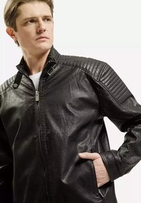 Czarna skórzana kurtka z pikowanymi ramionami, wysokim kołnierzem i zapięciem na zamek. Posiada boczne kieszenie i gładką teksturę. Akcenty w wykończeniu.