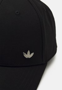 Black baseball cap made of textured fabric featuring a silver three-leaf logo on the front, with a curved brim and visible stitching details.