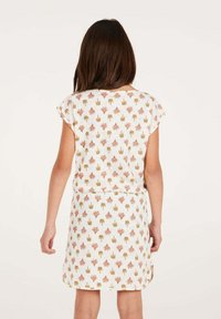 Korte mouwen jurk in het wit met een herhalend bladr dessin in roze en goud. Eenvoudige A-lijn silhouet, zachte textuurstof, knie-lengte.