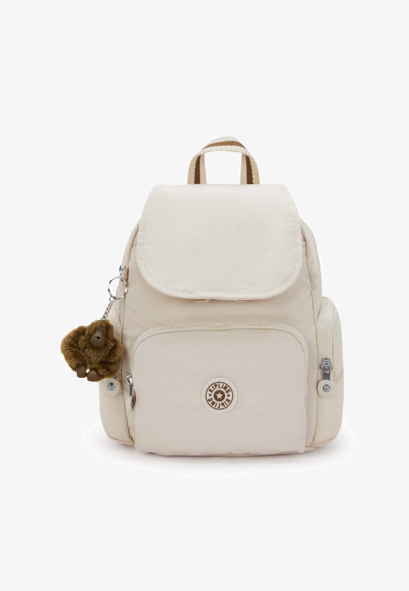 Kleiner beigefarbener Rucksack mit Fronttasche, seitlichen Reißverschlusstaschen, gestreiftem Griff und braunem Plüsch-Affen-Schlüsselanhänger.