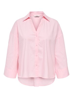 Blouse boutonnée rose clair avec manches larges trois quarts, un col et un ourlet arrière légèrement plus long.