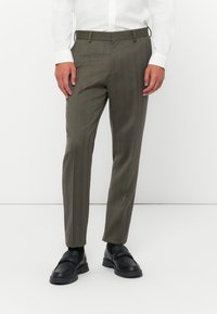 Skräddarsydda byxor med fiskbensmönster i olivgrön, med slim fit och plan front. Avslutade med bälteshällor och sidofickor.