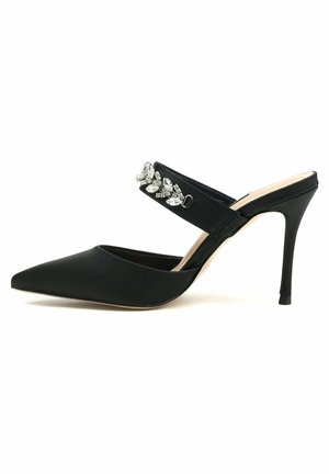 Talons aiguilles en satin noir à bride arrière, avec un nez pointu, une sangle ornée de pierres précieuses transparentes et un talon aiguille élancé. Texture lisse.