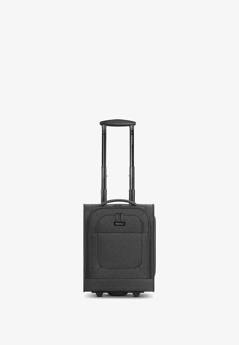 Maleta blanda compacta negra con mango telescópico extendido, bolsillo delantero con cremallera y dos ruedas pequeñas sobre fondo blanco.