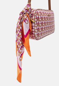 Hvid og pink mønstret håndtaske med brun kant, der har et silkeslør i orange, pink og hvid bundet om håndtaget. Guld hardware detalje.