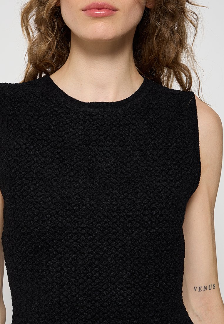 Schwarzes ärmelloses Top aus strukturiertem Stoff mit rundem Ausschnitt. Verfügt über ein unebenes Oberflächenmuster. Minimalistisches Design mit leichtem Schulteraufbau.