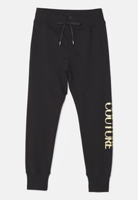 Schwarze Jogginghose aus weichem Material mit Kordelzug an der Taille und Seitentaschen. "COUTURE" in Gold auf dem linken Bein aufgedruckt.