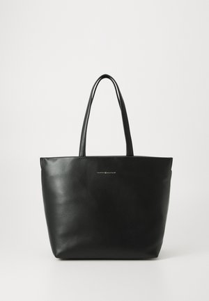 Black leather tote bag with two straps, smooth texture, and a logo on the front. Minimalist design with a vertical shape.