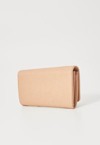 Ferskenfarget skinnlommebok med teksturert overflate, rektangulær form og brettedesign, med en søm langs kanten for ekstra detalj.