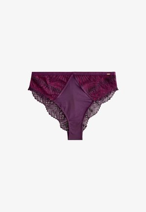 Lenjerie intimă pentru femei stil bikini din dantelă mov și satin, cu motive florale și margini ondulate, așezată pe o suprafață albă.