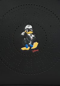 Artigo em couro preto com um desenho do Pato Donald usando óculos e um fraque. Existem pequenas perfurações dispostas em um padrão circular.